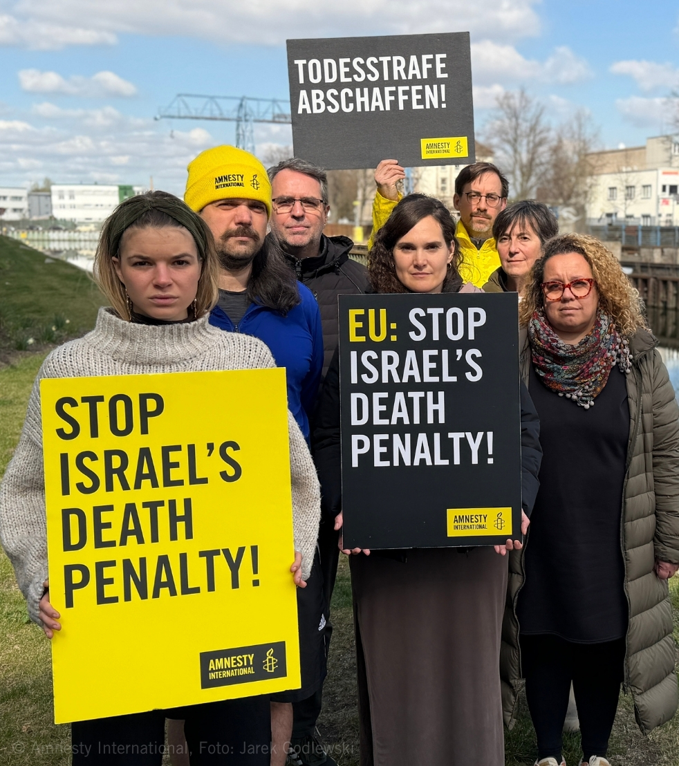 Das Foto zeigt mehrere Menschen, die Schilder gegen die Todesstrafe in Israel halten.